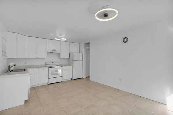 a large white kitchen with a sink window and stainless steel appliances