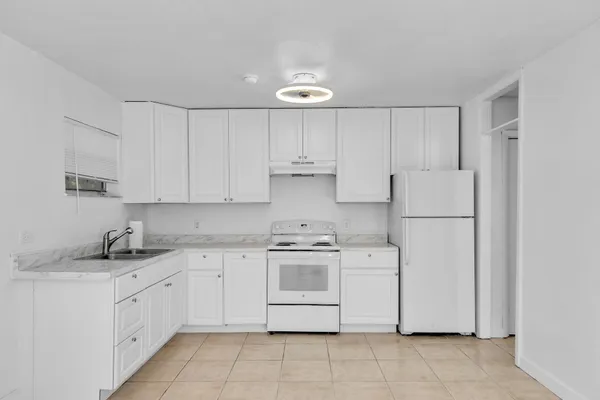 a kitchen with cabinets appliances a sink and a stove