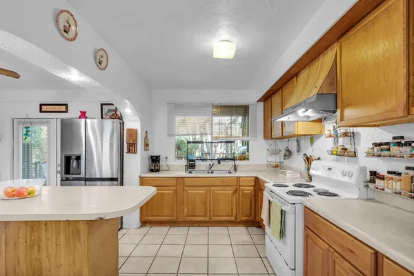 a kitchen with stainless steel appliances a stove refrigerator sink and cabinets