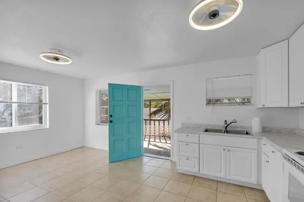 a kitchen with white cabinets and white appliances
