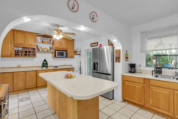 a kitchen with stainless steel appliances granite countertop a sink a stove cabinets counter space and a window