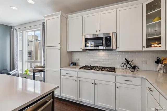 a kitchen with stainless steel appliances white cabinets and a stove top oven