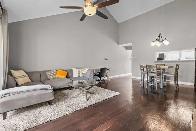 a living room with furniture and a dining table with wooden floor