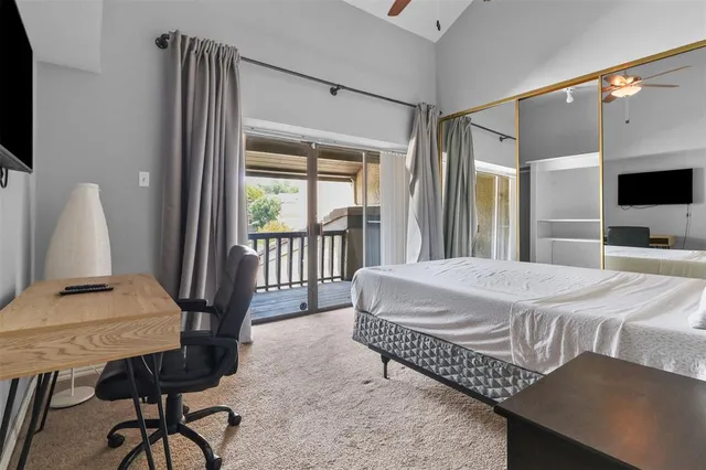 a bedroom with a bed window and a flat screen tv