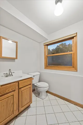 a bathroom with a toilet a sink and mirror