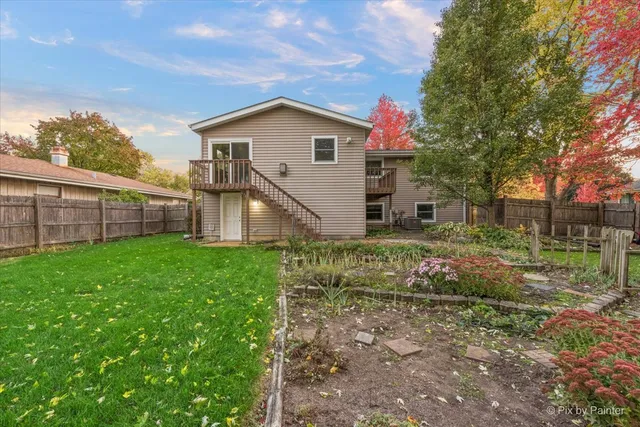a view of yard with small house and wooden fence