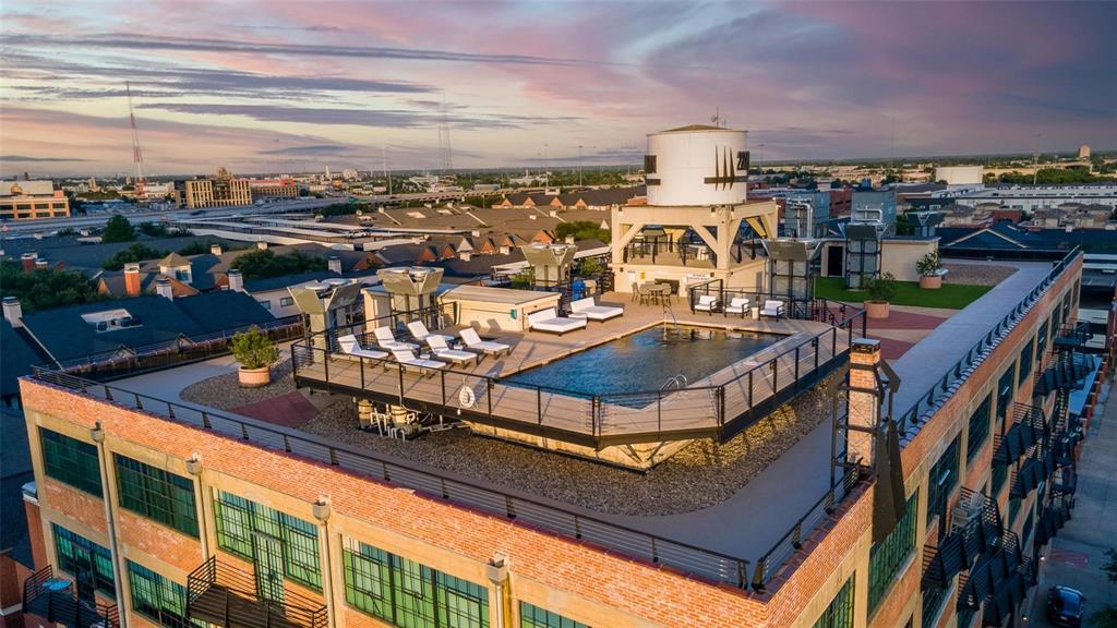 2220 Canton Street, Unit 101 Dallas, TX 75201 - Photo 14 of 20 Rooftop deck featuring a swimming pool, surrounding sun lounge area, and an elevated water tower structure