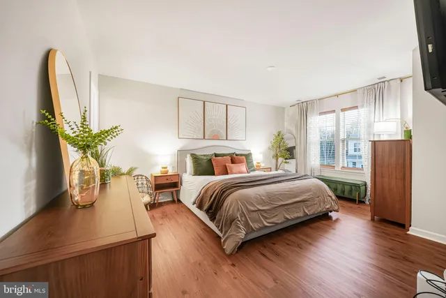 a bedroom with a large bed and a potted plant