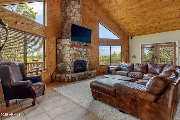 a living room with furniture a flat screen tv and a fireplace