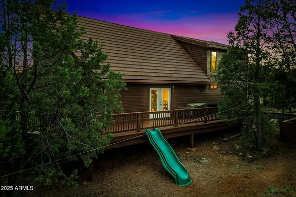 a backyard of a house with barbeque oven and trees