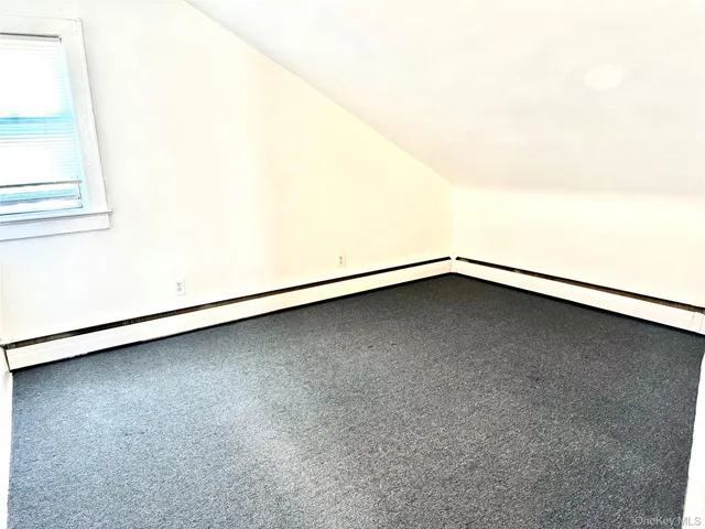 a view of a small space with wooden floor and a window