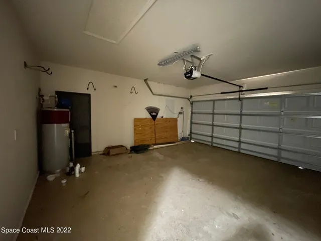 an empty room with wooden floor chandelier fan and windows