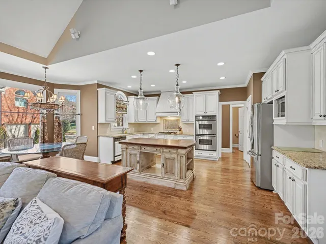 a kitchen with stainless steel appliances granite countertop a stove refrigerator and cabinets