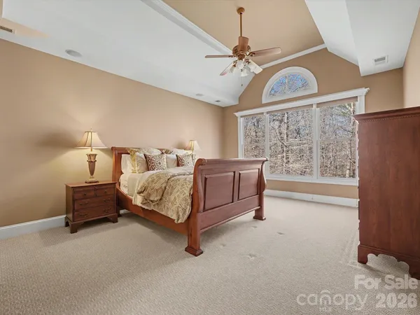 a bedroom with a bed lamp and a chandelier