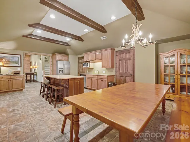 a kitchen with kitchen island a stove a sink a refrigerator dining table and chairs