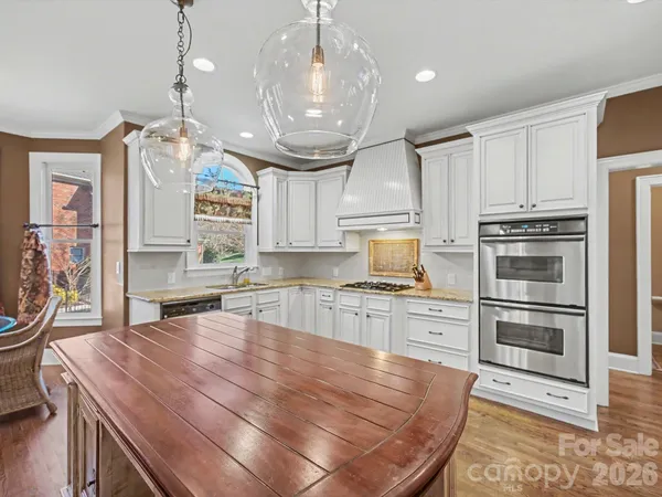a kitchen with stainless steel appliances granite countertop a stove refrigerator and cabinets