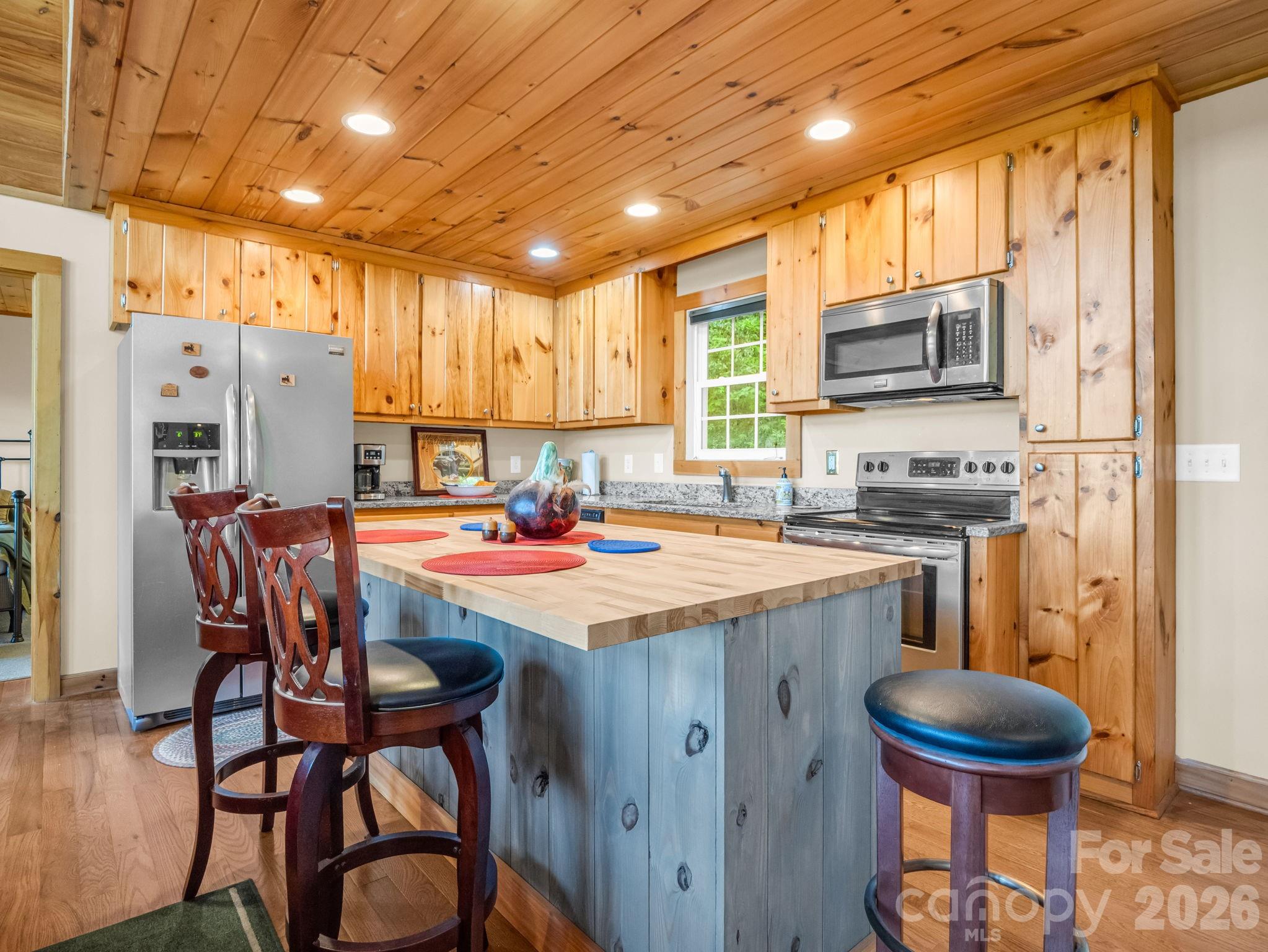 603 Pace Mountain Road Saluda, NC 28773 - Photo 16 of 44 a kitchen with stainless steel appliances kitchen island granite countertop a table chairs and a refrigerator