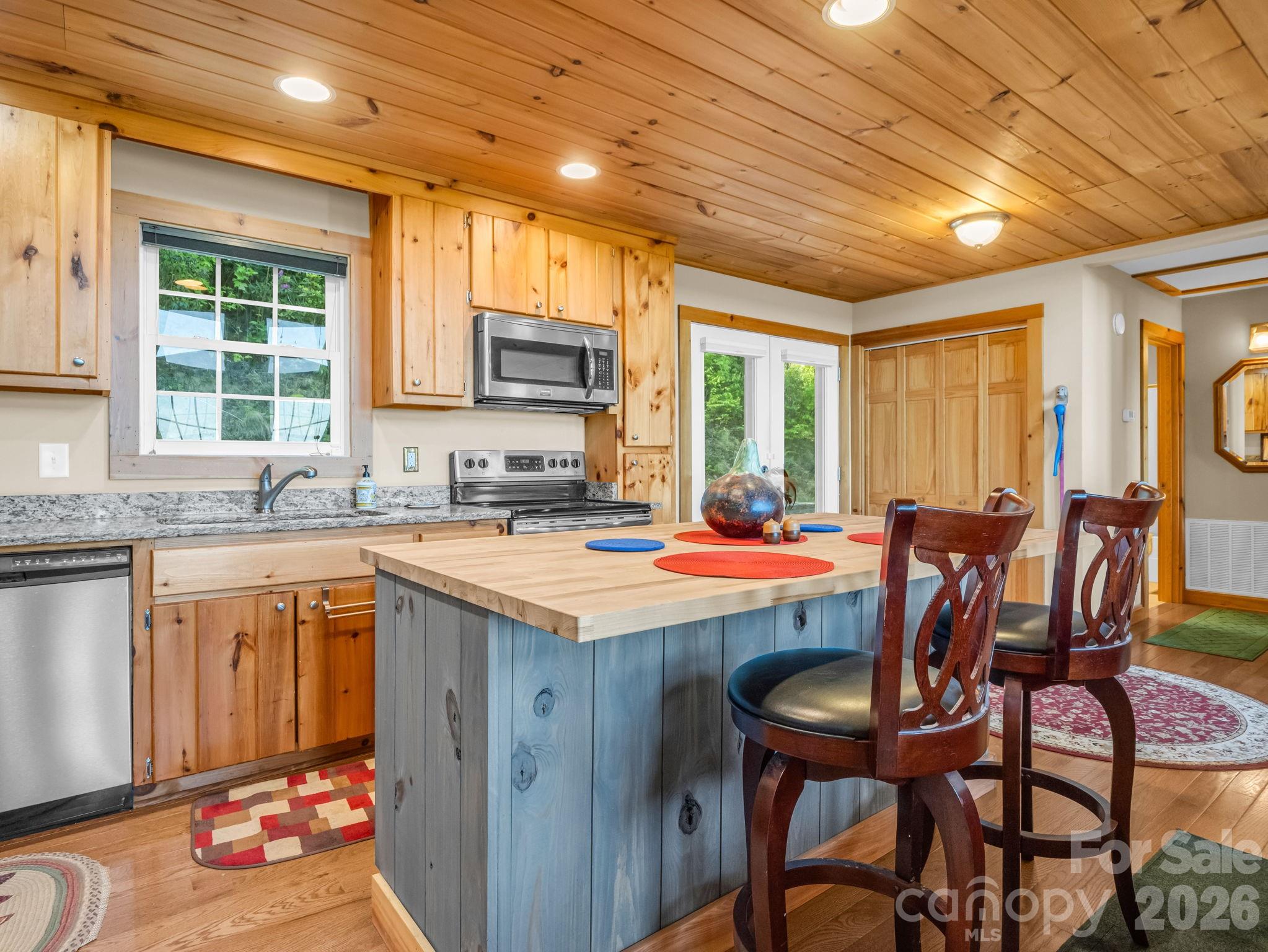 603 Pace Mountain Road Saluda, NC 28773 - Photo 17 of 44 a kitchen with a stove a sink dishwasher a dining table and chair with wooden floor