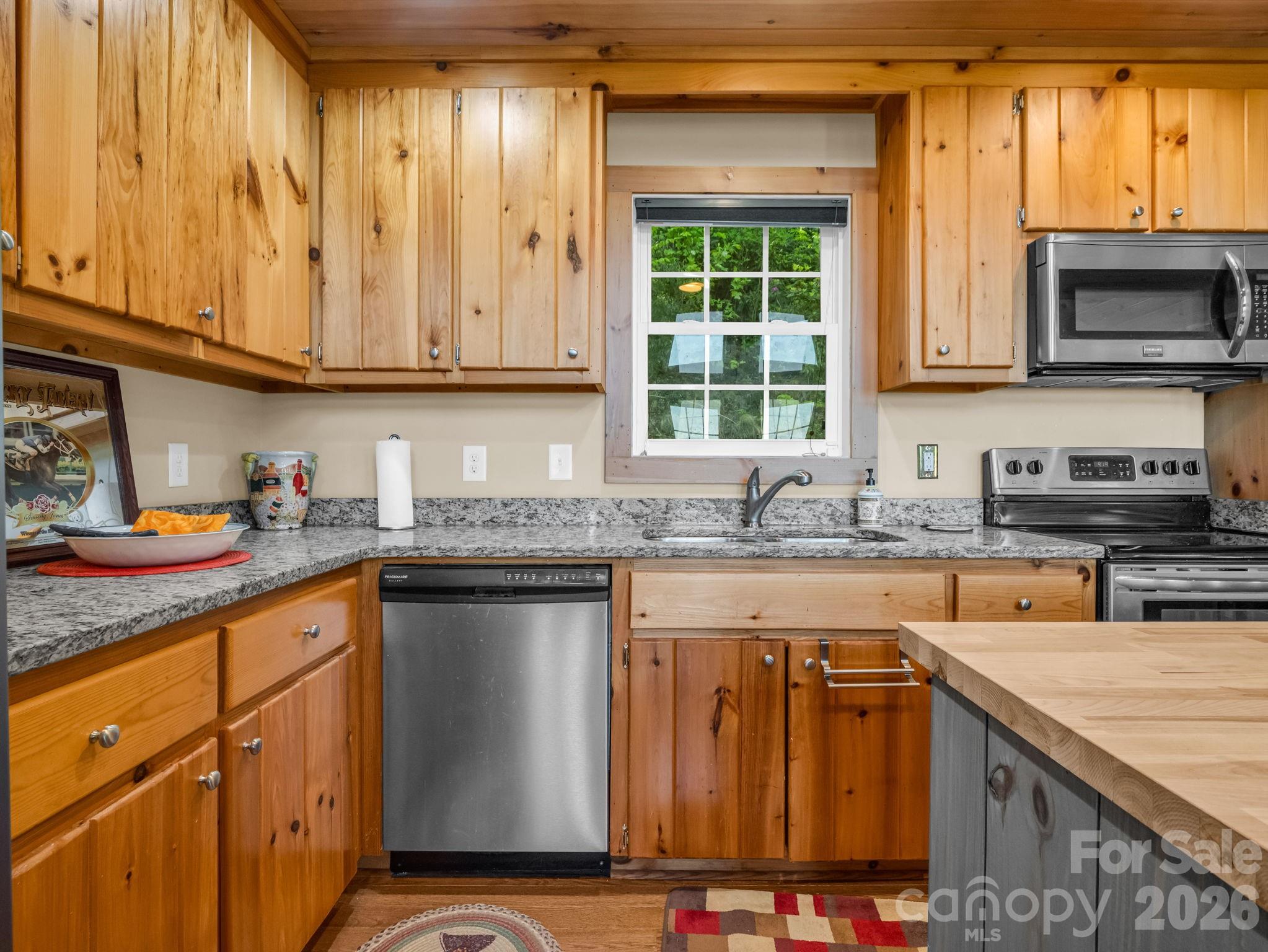 603 Pace Mountain Road Saluda, NC 28773 - Photo 18 of 44 a kitchen with stainless steel appliances granite countertop a sink stove and cabinets