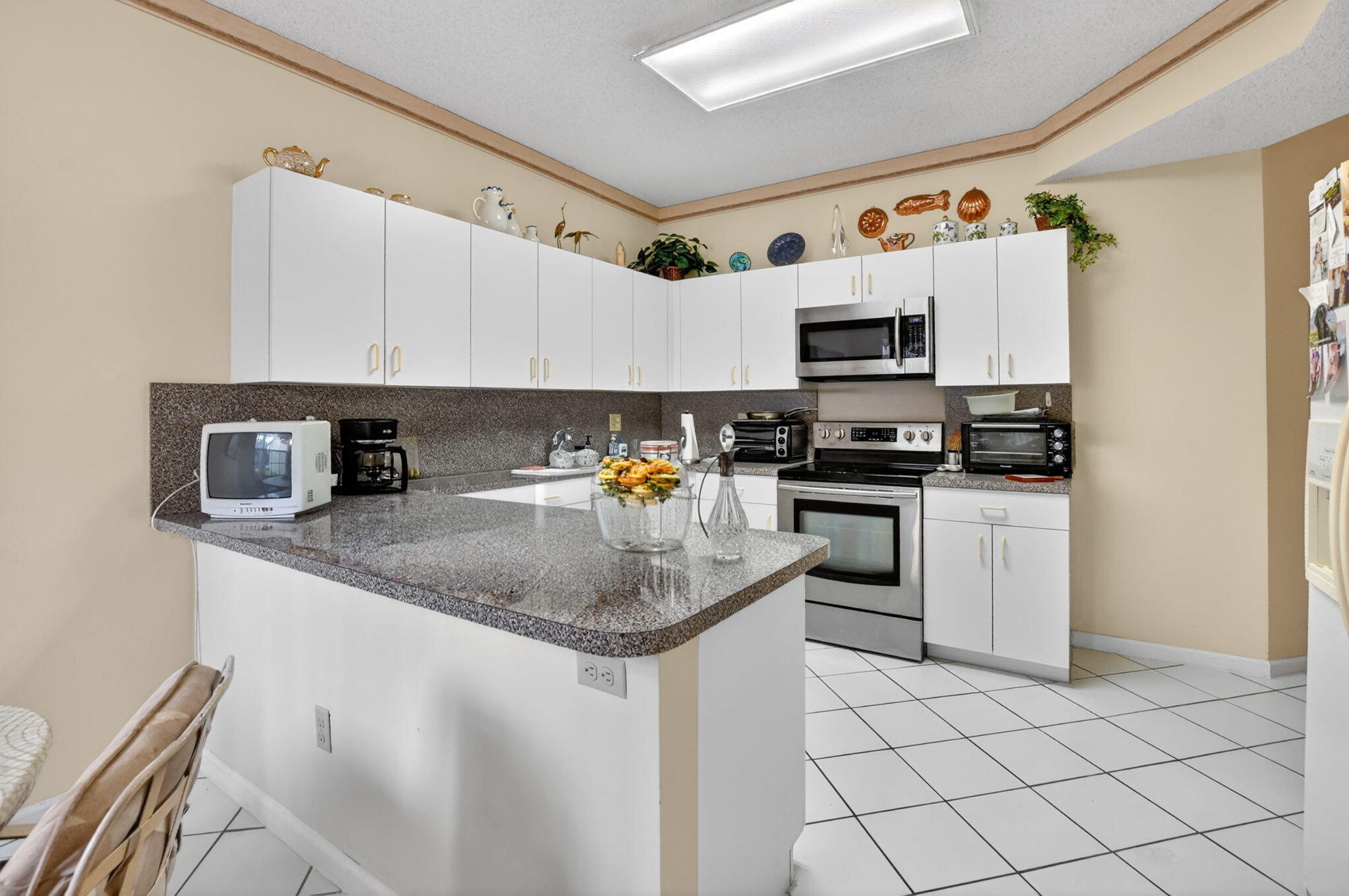 6683 Montego Bay Boulevard, Unit C Boca Raton, FL 33433 - Photo 18 of 37 a kitchen with white cabinets sink and appliances