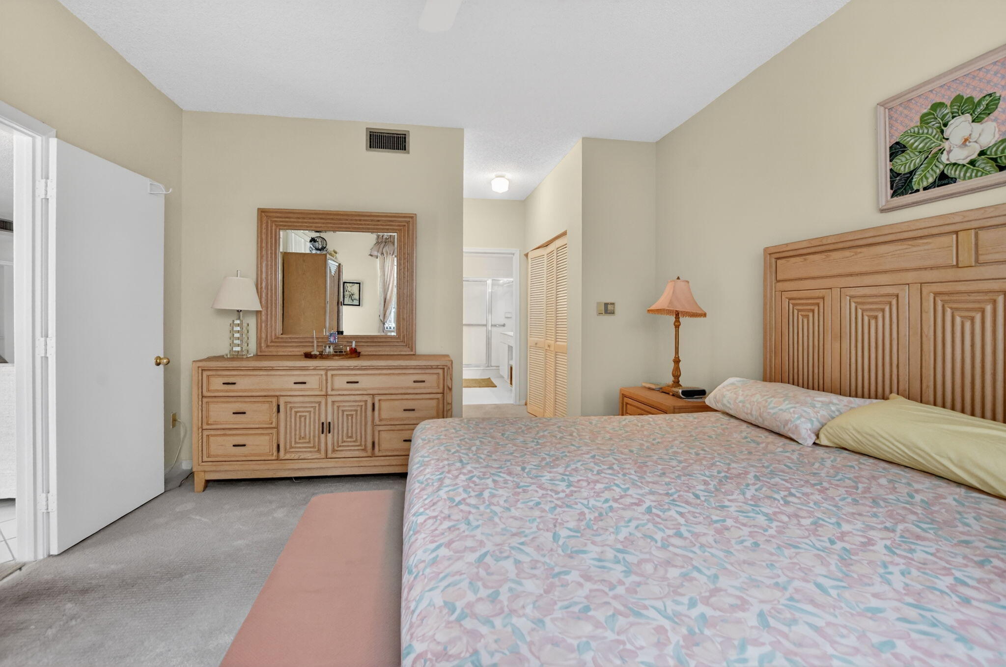 6683 Montego Bay Boulevard, Unit C Boca Raton, FL 33433 - Photo 21 of 37 a bedroom with a bed a dresser and a mirror