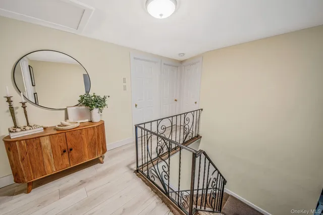 a view of a hallway with wooden floor and stairs
