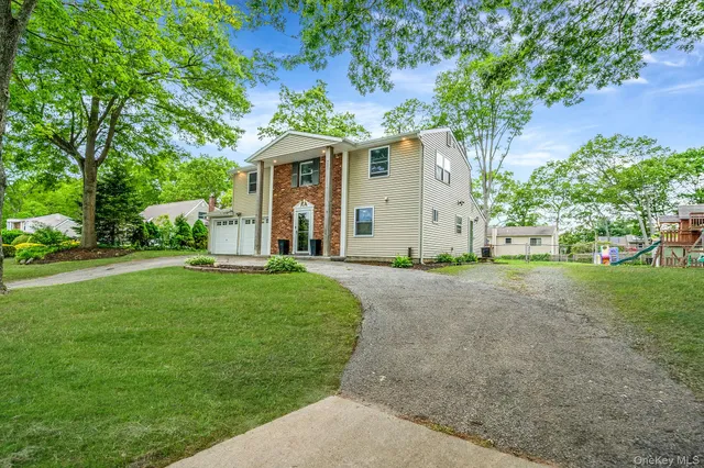 a front view of a house with a yard and trees