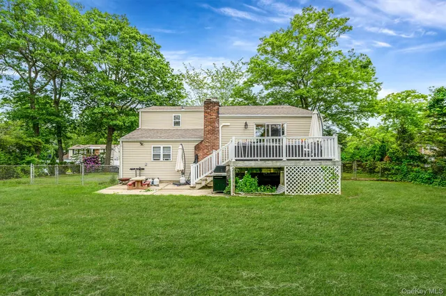 a white house with a big yard and large trees