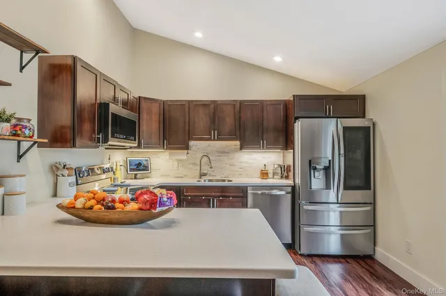 a kitchen with stainless steel appliances a refrigerator sink and microwave