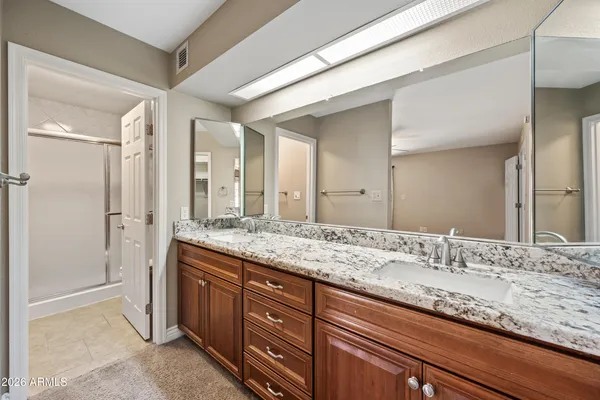 a bathroom with a granite countertop sink and a mirror