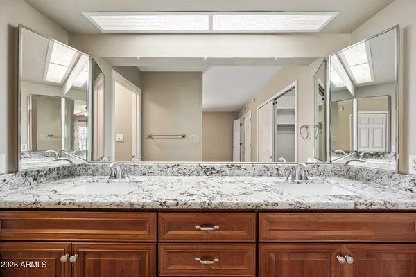 a bathroom with granite countertop sink and a mirror