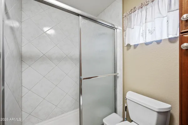 a white toilet sitting next to a shower