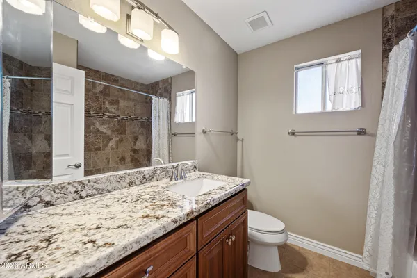 a bathroom with a granite countertop sink toilet and shower