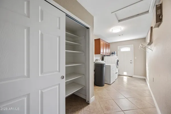 a kitchen with a refrigerator and white cabinets