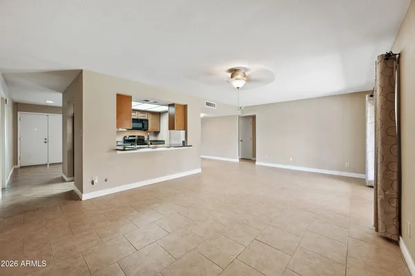 a view of a livingroom with wooden floor and a kitchen