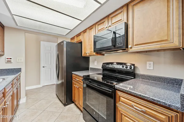 a kitchen with stainless steel appliances granite countertop a refrigerator and a stove