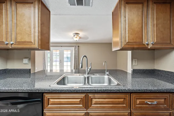 a kitchen with granite countertop a sink and cabinets