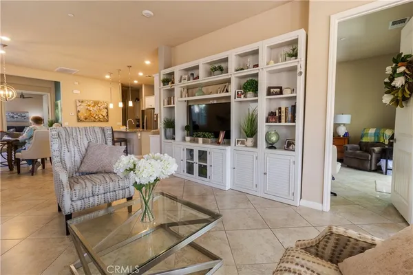 a living room with furniture a flat screen tv and a view of kitchen
