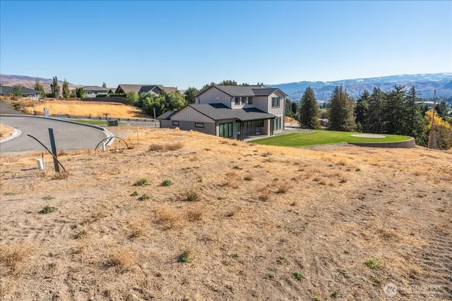 an aerial view of a house with a yard and lake view in back
