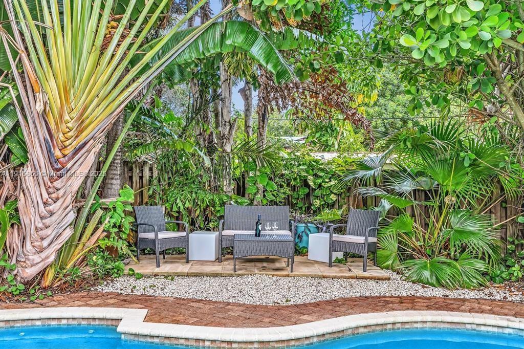 1577 Northeast 48th Court Oakland Park, FL 33334 - Photo 13 of 21 a front view of a house with garden