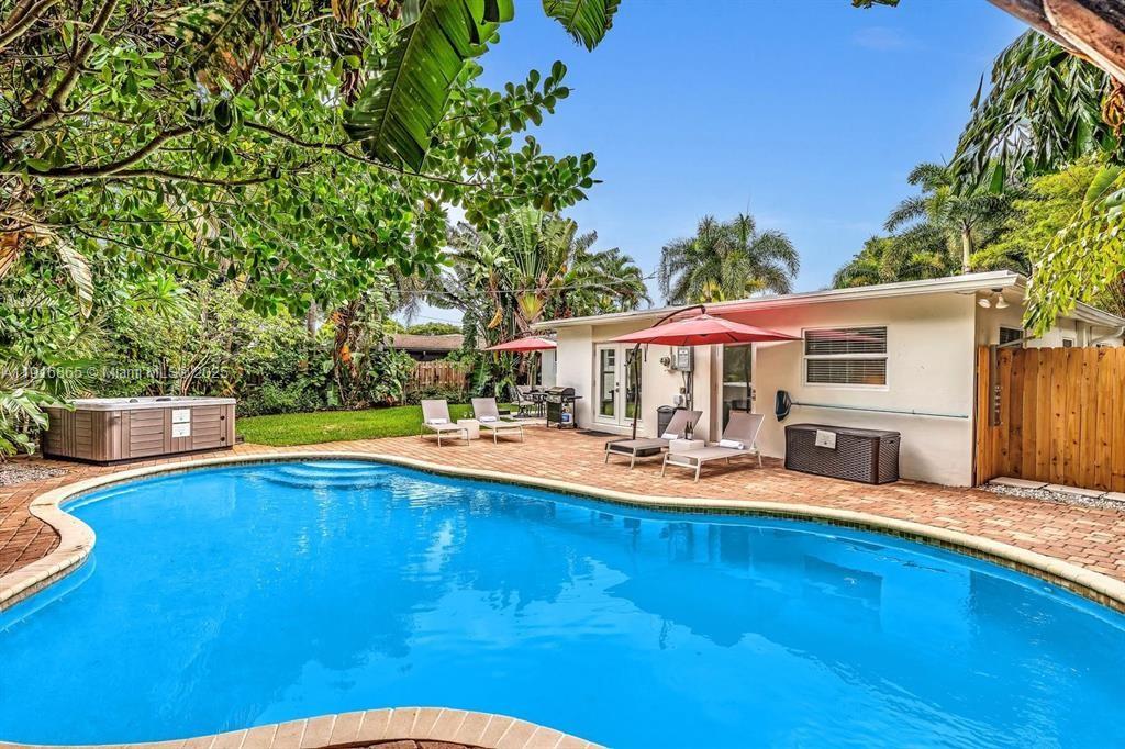 1577 Northeast 48th Court Oakland Park, FL 33334 - Photo 14 of 21 a view of a house with swimming pool and sitting area
