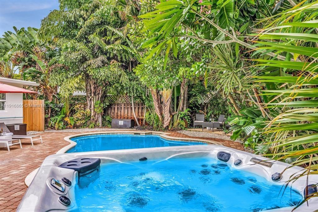 1577 Northeast 48th Court Oakland Park, FL 33334 - Photo 19 of 21 a view of backyard with swimming pool and seating space