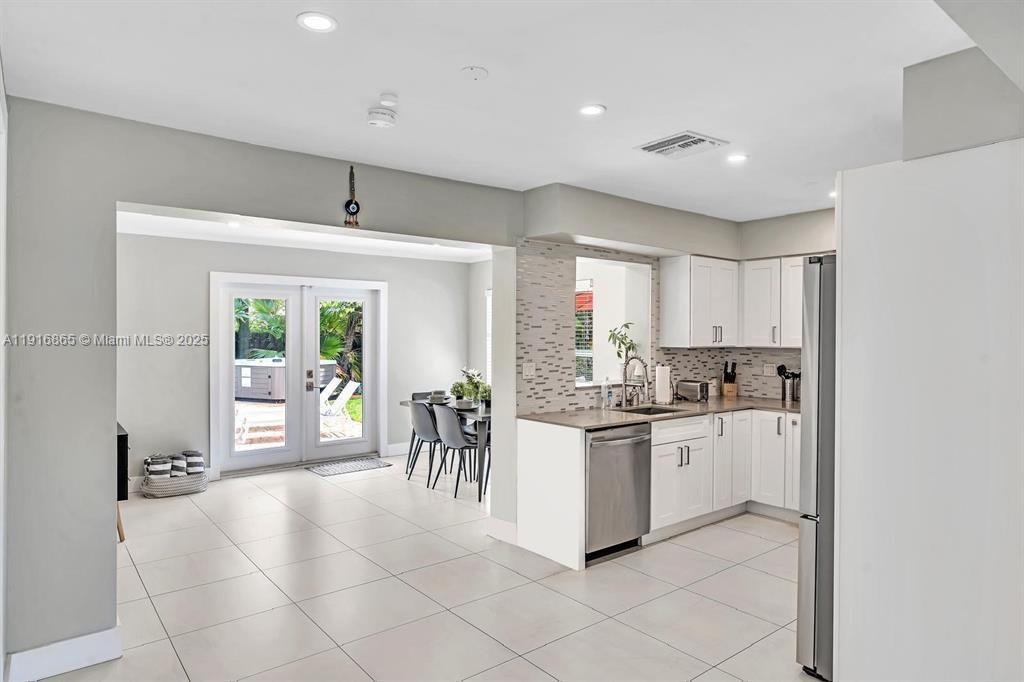1577 Northeast 48th Court Oakland Park, FL 33334 - Photo 2 of 21 a kitchen with appliances cabinets and a table