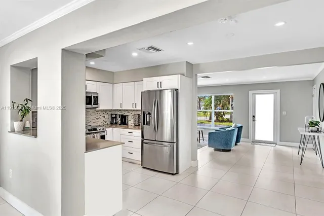 a kitchen with stainless steel appliances a refrigerator sink and cabinets