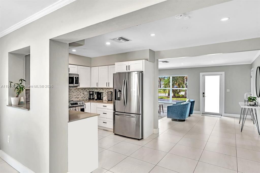 1577 Northeast 48th Court Oakland Park, FL 33334 - Photo 3 of 21 a kitchen with stainless steel appliances a refrigerator sink and cabinets