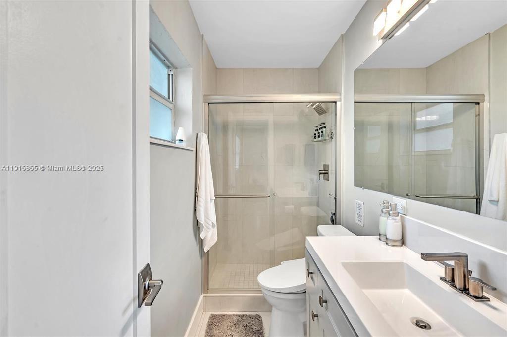 1577 Northeast 48th Court Oakland Park, FL 33334 - Photo 5 of 21 a bathroom with a sink toilet and shower