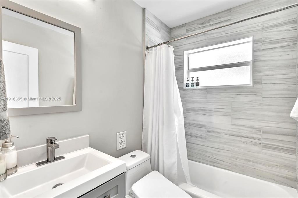 1577 Northeast 48th Court Oakland Park, FL 33334 - Photo 6 of 21 a bathroom with a sink toilet and shower