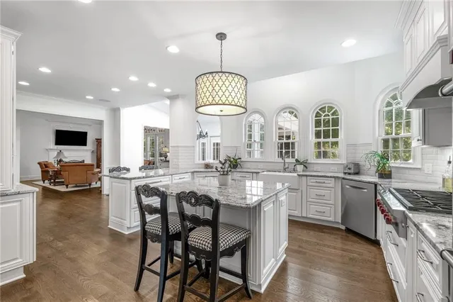a living room with furniture a chandelier and a flat screen tv