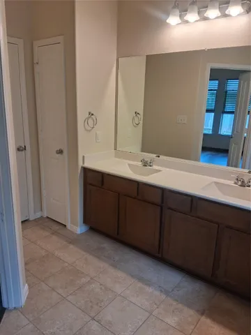 a spacious bathroom with a double vanity sink and a mirror