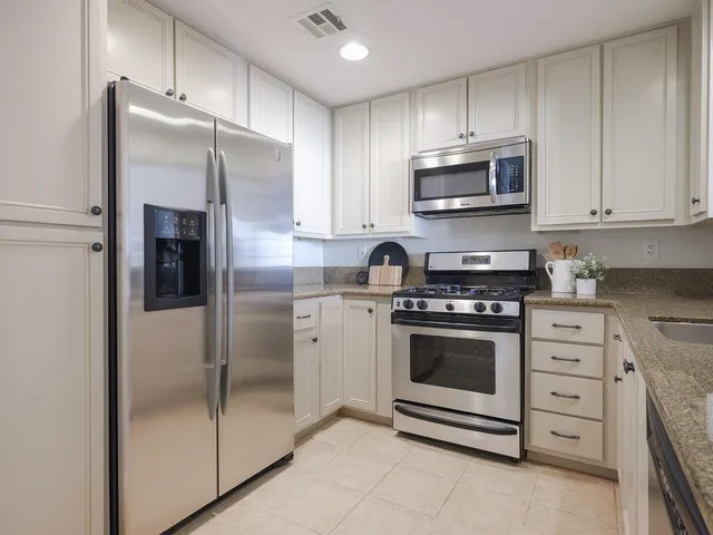 a kitchen with stainless steel appliances granite countertop a refrigerator stove and microwave